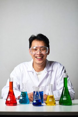 Asian man in lab coat with colored beakers