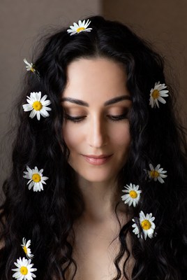 Woman with daisies in curly black hair