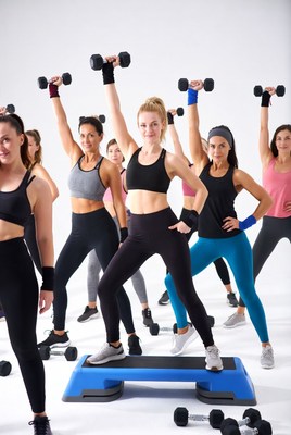 Women lifting dumbbells on step platform
