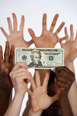 Diverse hands holding twenty dollar bill