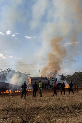 Firefighters battling wildfire with truck