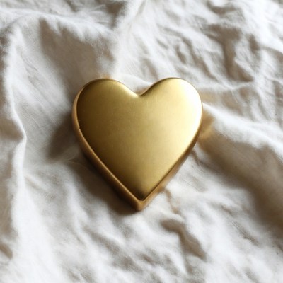 Gold heart on white fabric