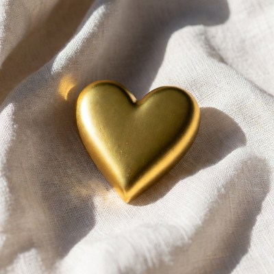 Golden heart on white fabric