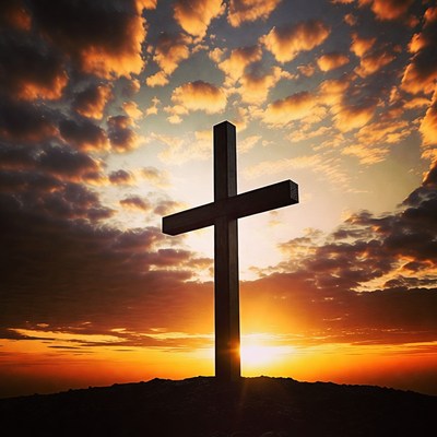 Cross on hill at sunset