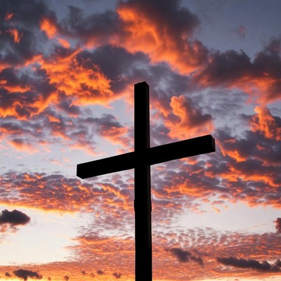 Black Cross Silhouetted Against Sunset Sky