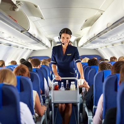 Flight attendant serving drinks on airplane