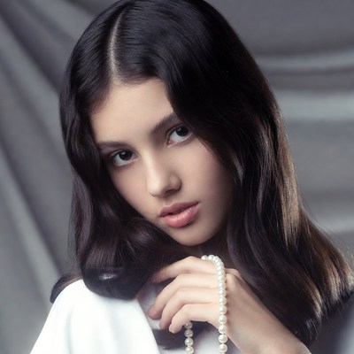 Young girl holding pearl necklace