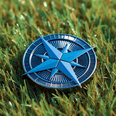 Blue compass on green grass
