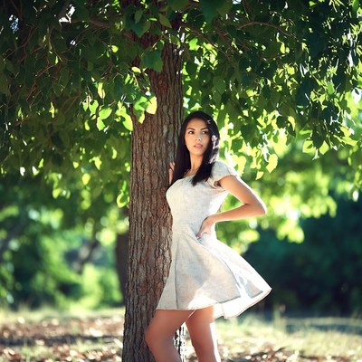 Woman leaning against tree