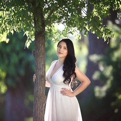 Asian woman in white dress by tree