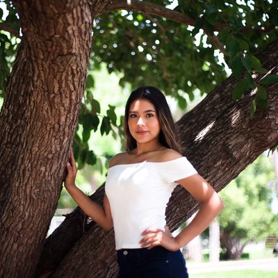 Young woman leaning against tree