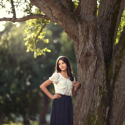 Girl leaning against tree