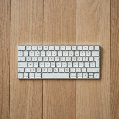 White Apple Keyboard on Wooden Surface