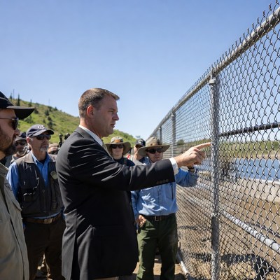 Man pointing at chain-link fence