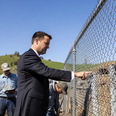 Man pointing at border fence