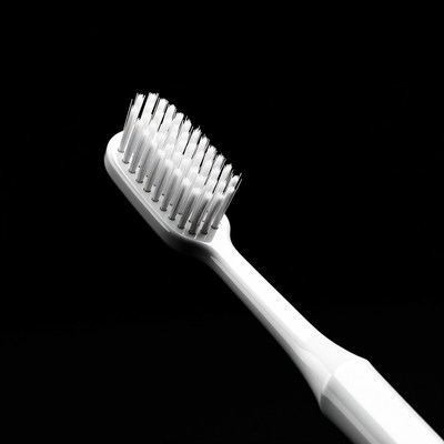 White Toothbrush on Black Background