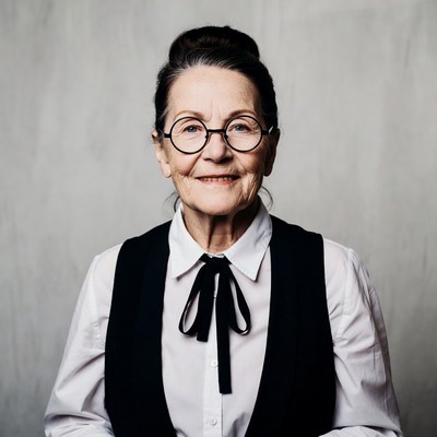 Elderly woman wearing glasses and vest