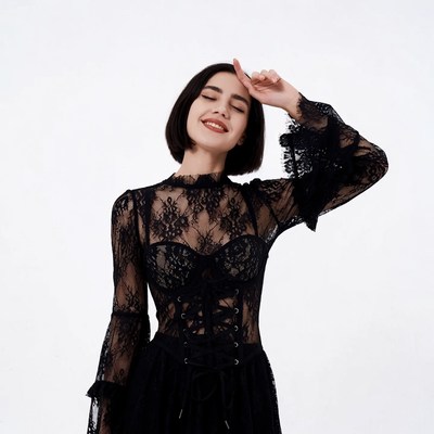 Woman in black lace dress touching forehead