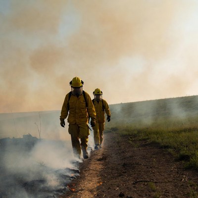 Two firefighters walking wildfire path