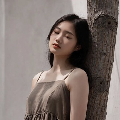 Asian woman leaning against tree