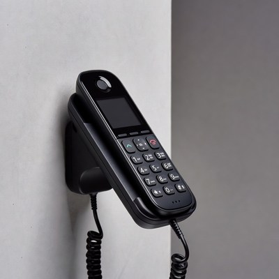 Black corded phone on wall