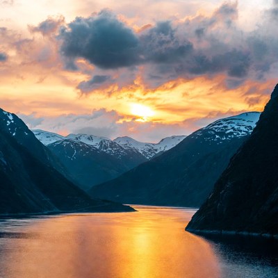 Sunset over snowy mountains and fjord