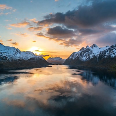 Sunset over snowy mountains and fjord
