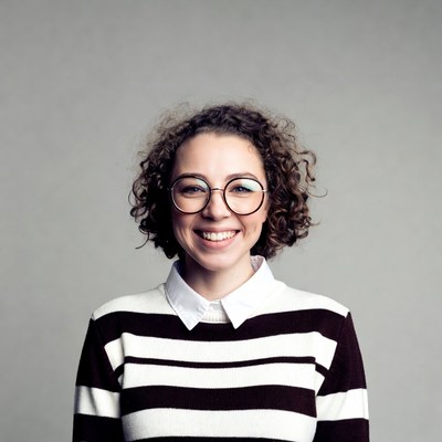 Smiling woman with curly hair and glasses