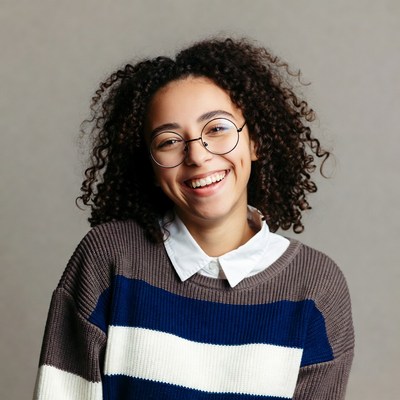 Smiling young woman with curly hair and glasses
