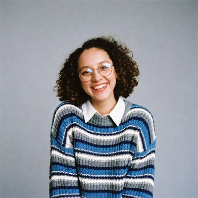 Smiling woman in blue sweater with glasses