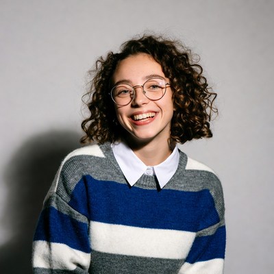 Smiling woman with curly hair and glasses