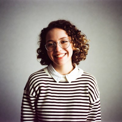 Smiling woman with curly hair and glasses