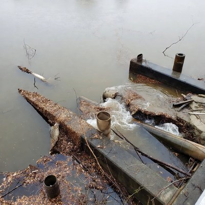 Rusty Pipes on Frozen River Edge