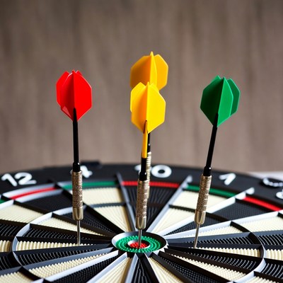 Colorful darts hitting bullseye on dartboard