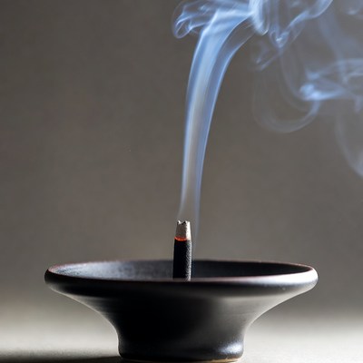 Incense stick burning in black holder