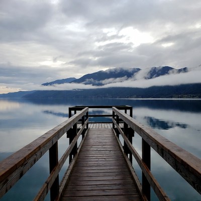 Wooden pier over misty mountain lake