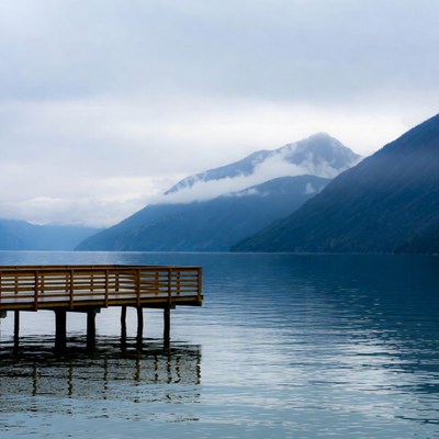 Wooden pier on misty mountain lake