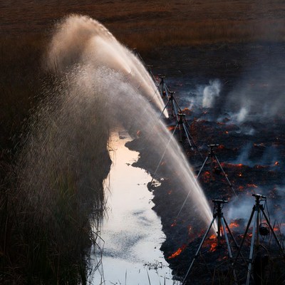 Water Sprayers Extinguishing Marsh Fire