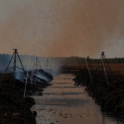 Firefighters spraying water on wildfire