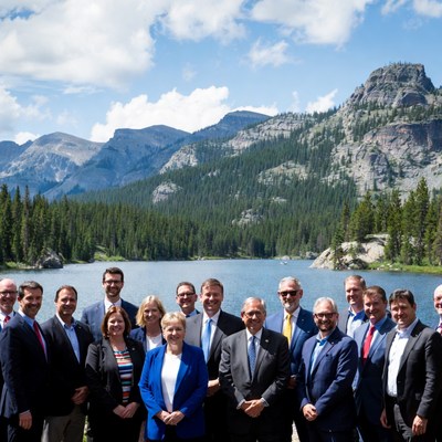 Business group posing by mountain lake