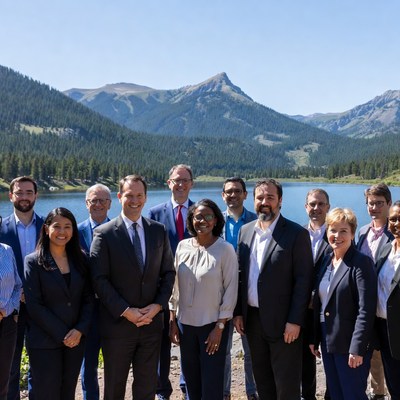 Group of professionals posing by mountain lake