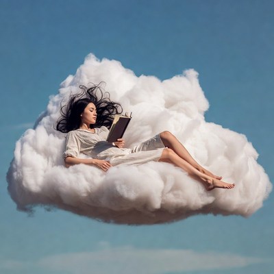 Asian woman reading book on clouds