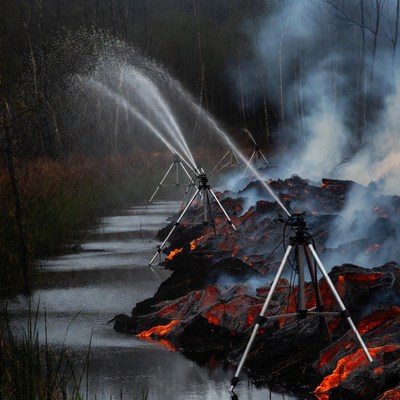 Firefighters spraying water on forest fire