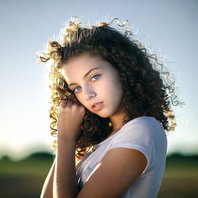 Girl with curly hair in field