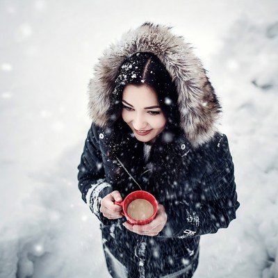 Woman holding coffee in snowy winter