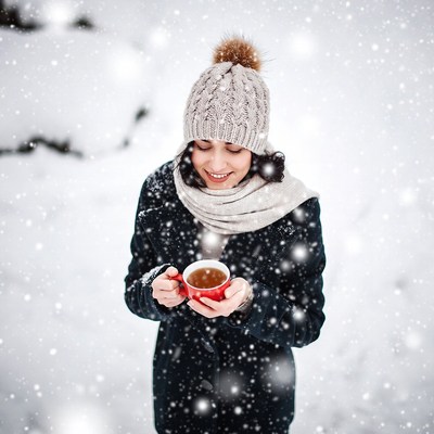 Woman holding red mug in snowy winter