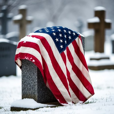 American flag draped gravestone in snowy cemetery