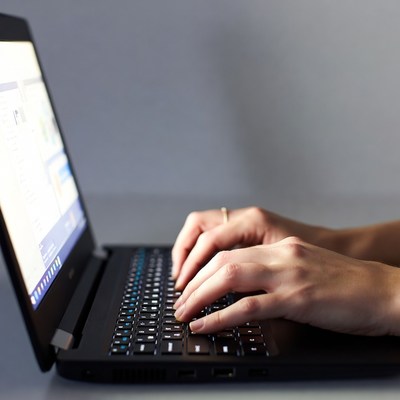 Woman typing on laptop keyboard