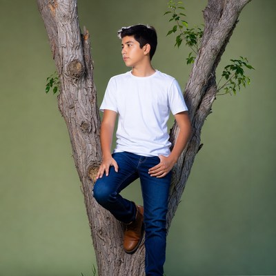 Boy leaning against tree
