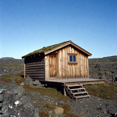 Wooden turf-roof cabin on rocky landscape